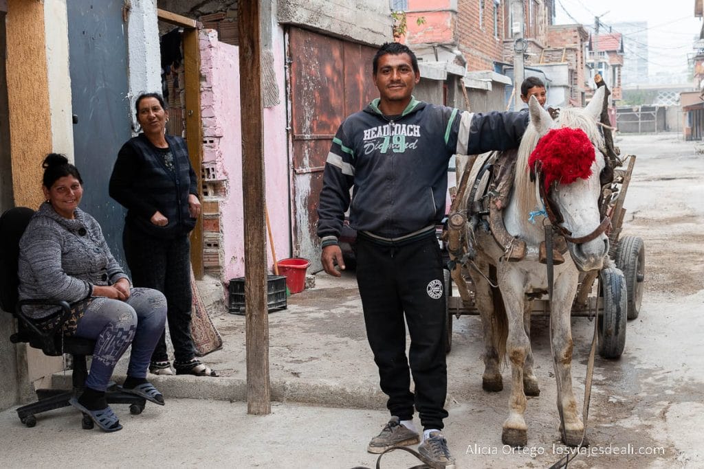 hombre con su taliga y caballo con pompón rojo