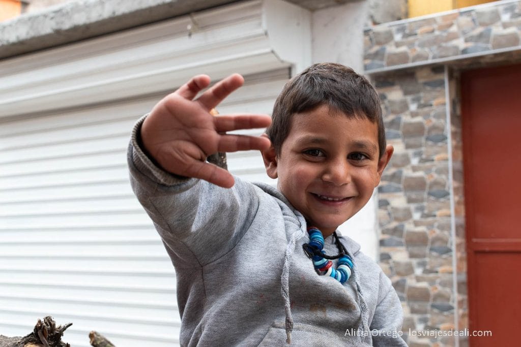 niño gitano saludando con su mano y sonriendo