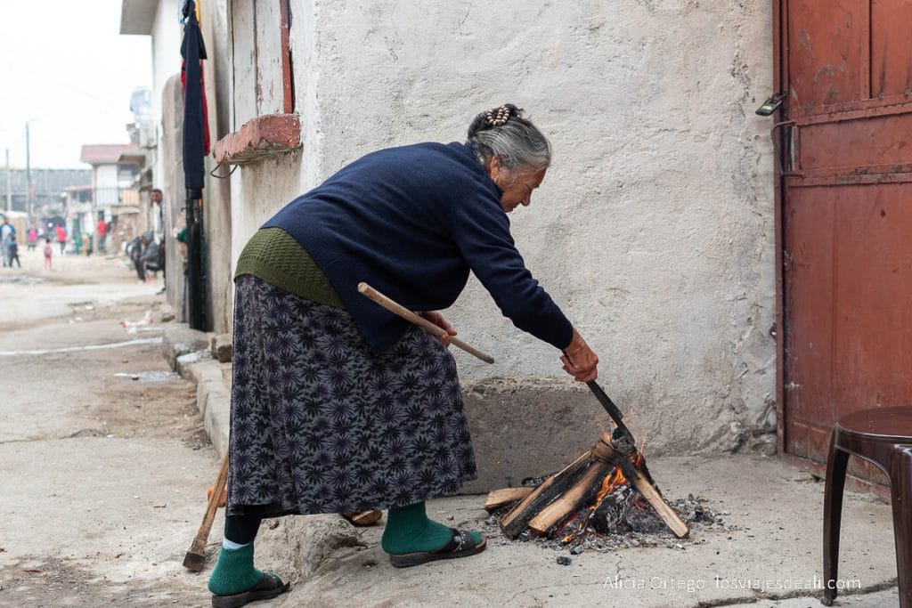 mujer encendiendo una hoguera en la calle