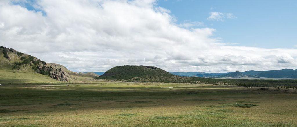 valle de khorgo con el volcán y delante un gran prado de hierba en mongolia central