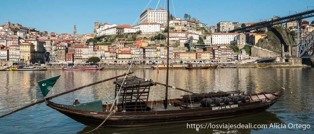 vista de la ribeira de oporto desde la orilla de enfrente con un barco de madera en primer plano