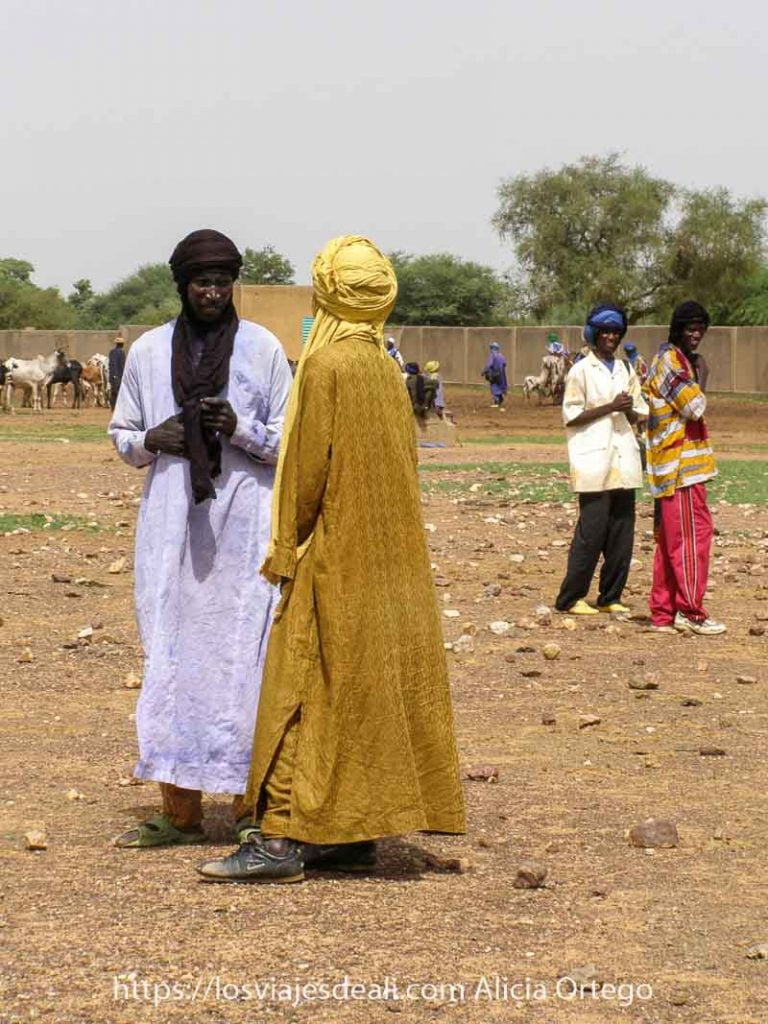 Mi primer mercado africano en el Sahel de Burkina Faso: Gorom Gorom 64 dos tuareg vestidos de color amarillo y morado hablando en el mercado africano de gorom gorom