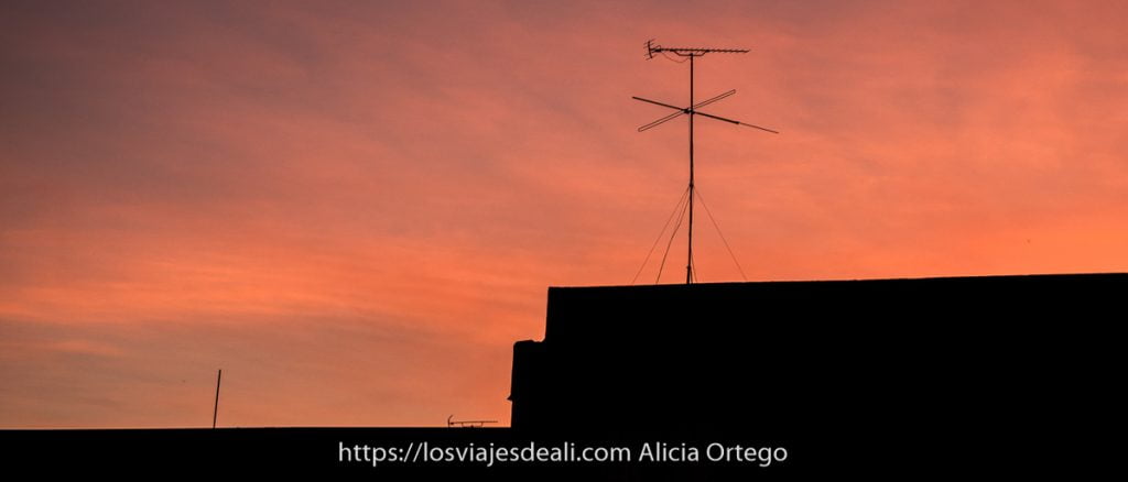 Radio a la carta y otros recursos internautas para viajar desde casa 11 antena de televisión sobre tejado con cielo rojo de atardecer viajar desde casa