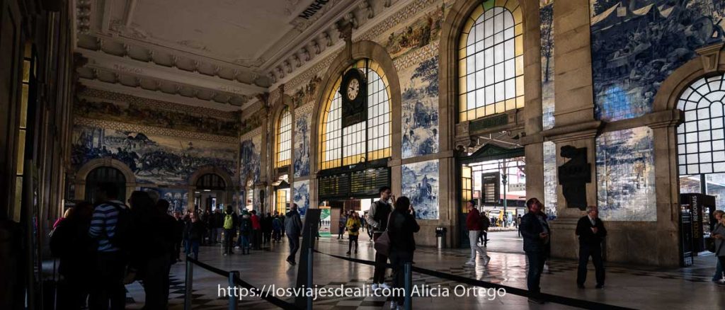 vestíbulo de la estación de são bento con gente admirando los paneles de azulejos