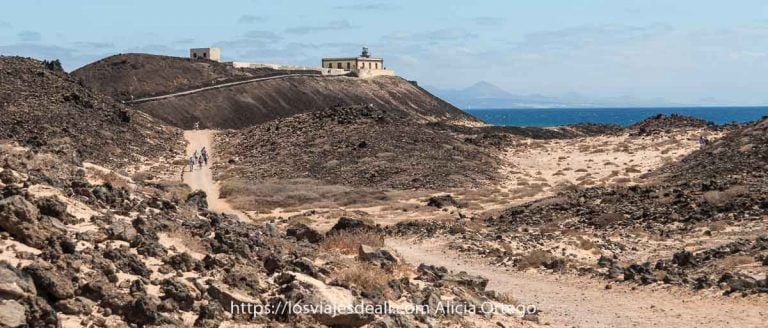 faro de Martiño al final del camino entre rocas volcánicas y suelo arenoso en la Isla de Lobos