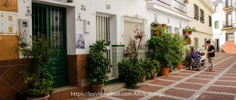 consejos para sentirte como un local calle de casas bajitas blancas con plantas en las puertas y dos señoras hablando