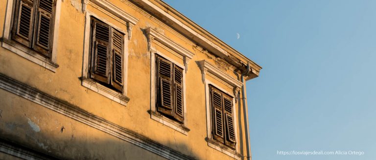 fachada de shkoder de color amarillo con la luna en el cielo