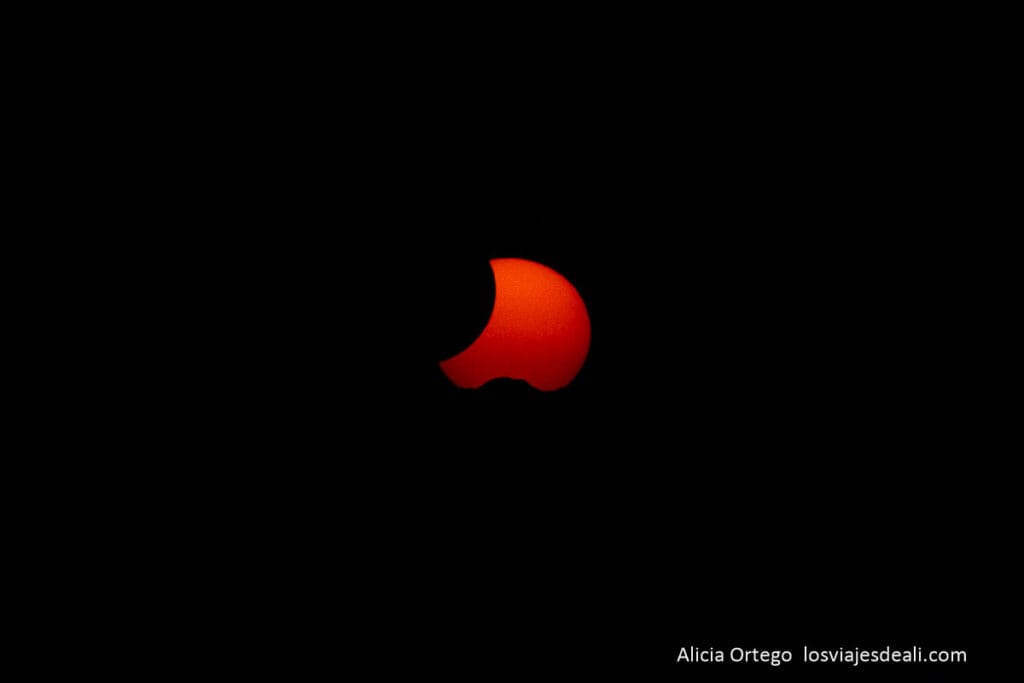 sol rojo con fase parcialidad ocultándose al atardecer