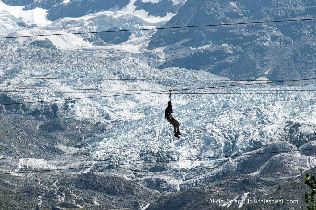 chico montado en tirolina con el glaciar del rakaposhi detrás