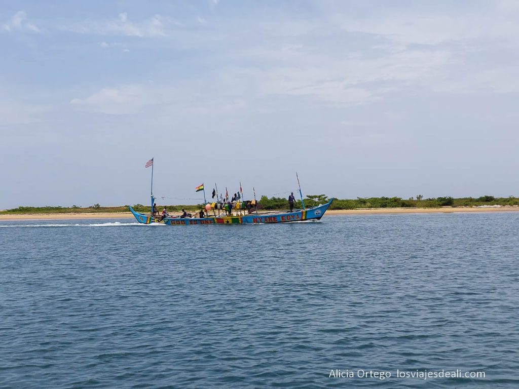 barco de pesca navegando junto a un banco de arena