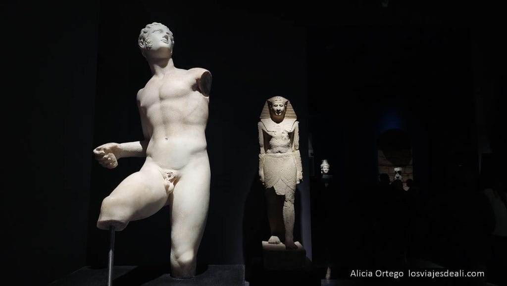 estatua romana y egipcia en el museo, rodeadas de oscuridad