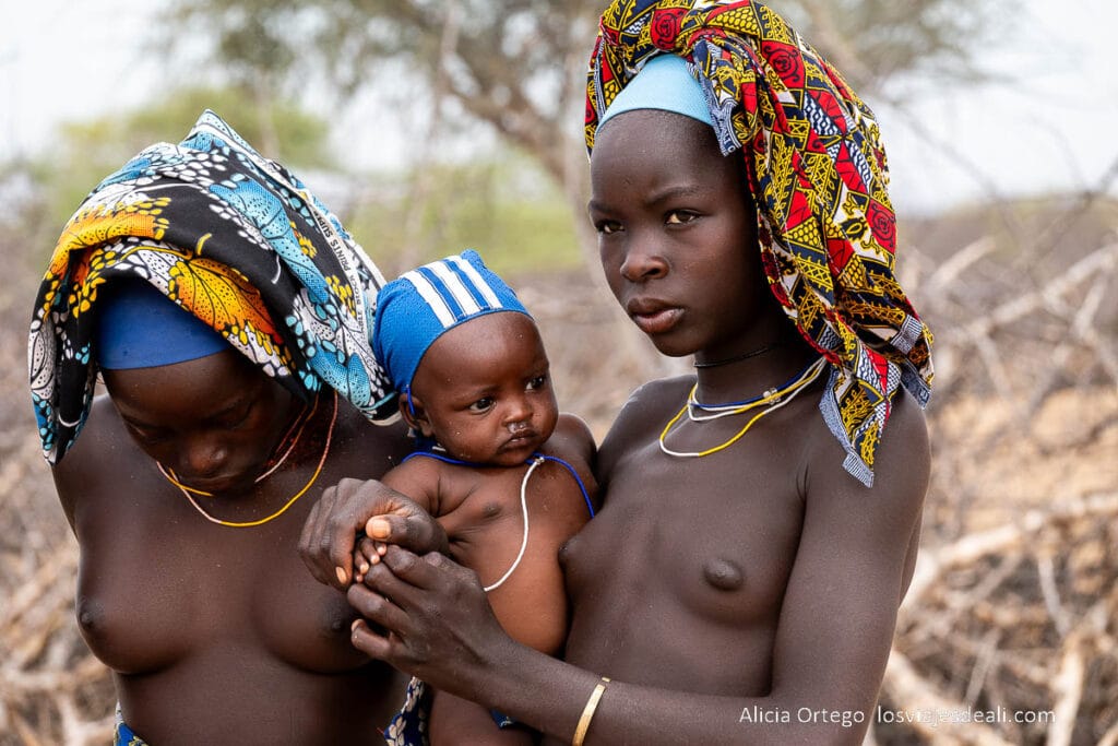 dos mujeres de la tribu mucubal con un bebé