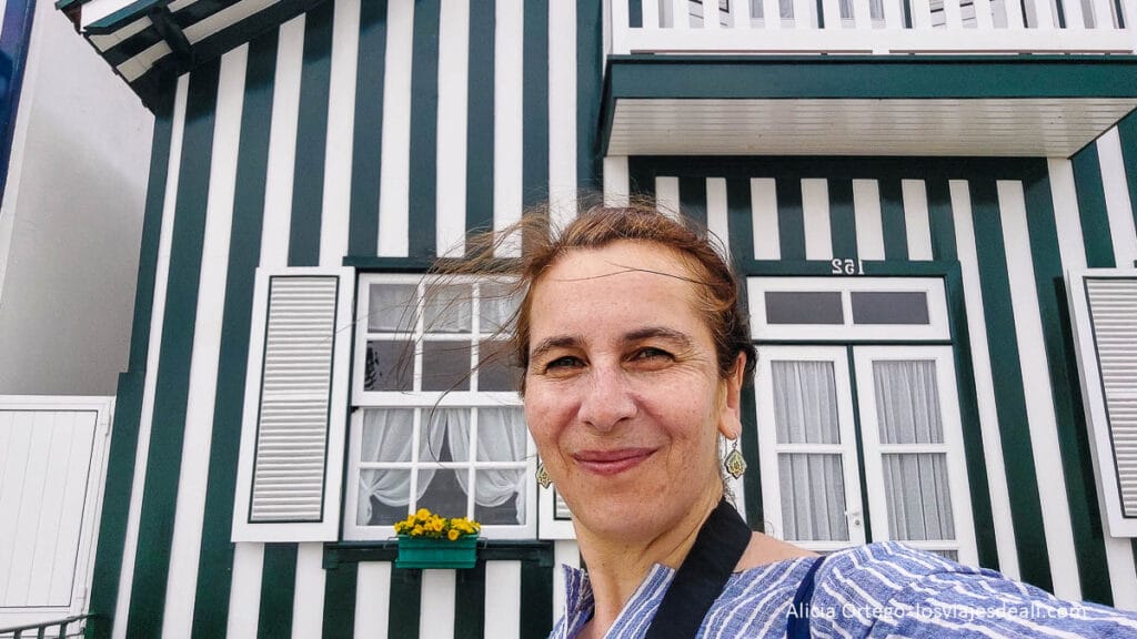 selfie con una casa pintada de rayas o palheiro